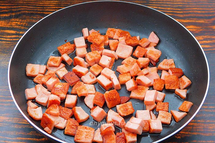 Колбасу нарезать кубиками и обжарить на сковороде