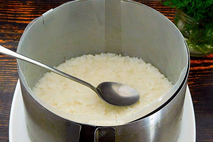В кулинарном кольце первым слоем выложить рис