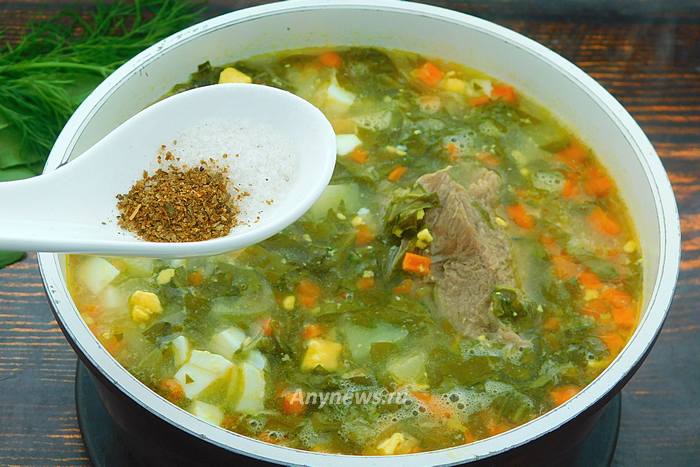 Щавелевый суп снять с плиты, посолить и приправить
