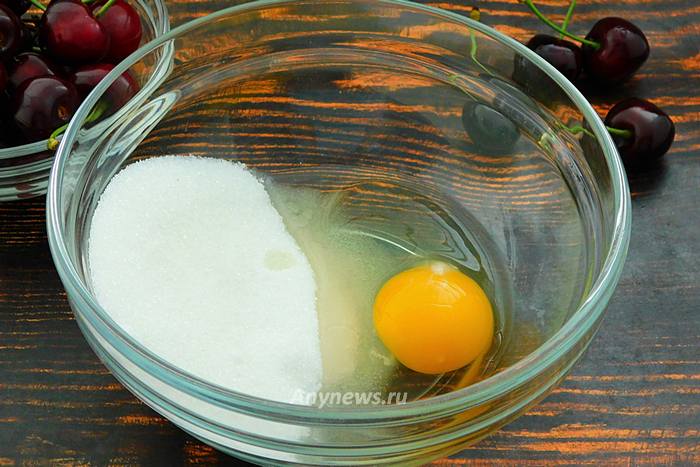 В миску всыпать сахар и разбить яйцо