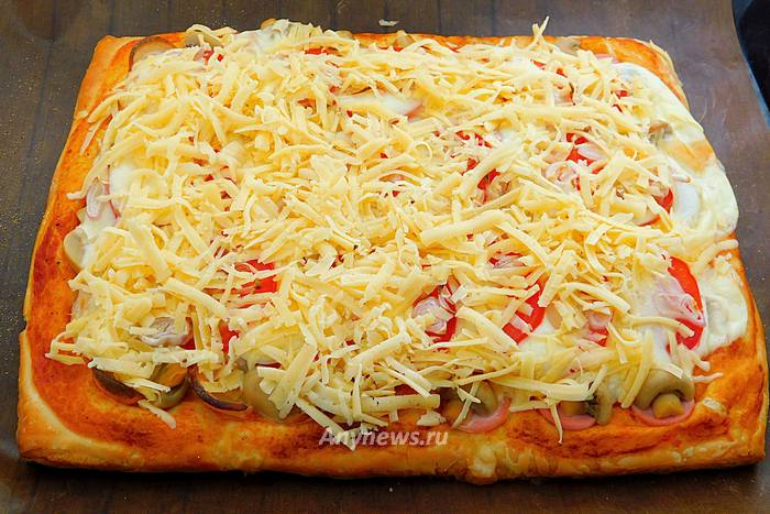 Посыпать пиццу тертым твердым сыром