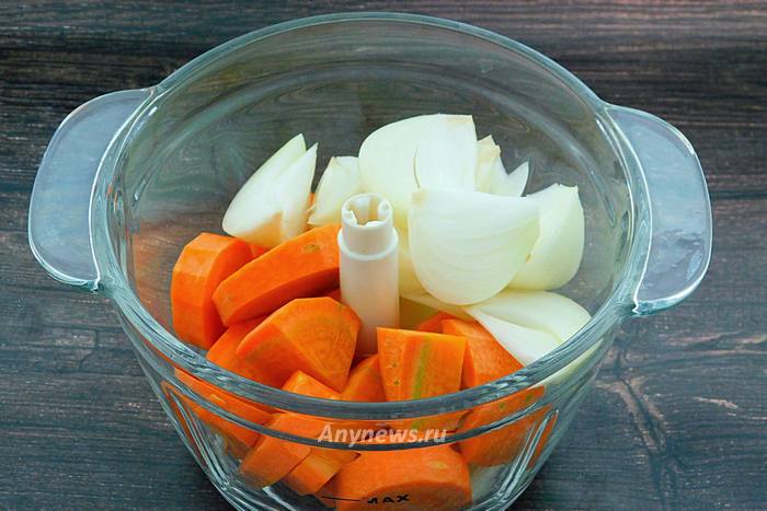 Кусочки моркови и лука сложить в чашу кухонного комбайна