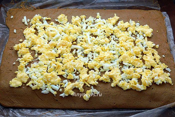 Выложить на пласт паштета яйца и сыр