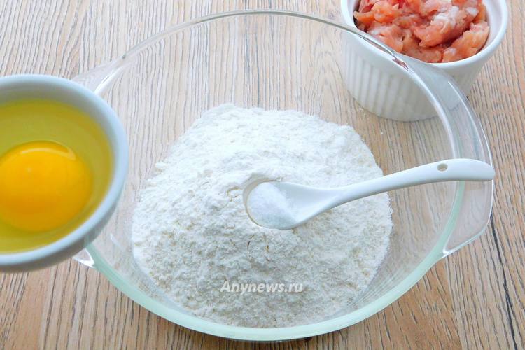 Муку насыпать в миску, добавить соль, разбить яйцо