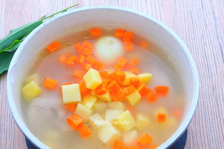 Высыпать овощи и целую луковицу к курице