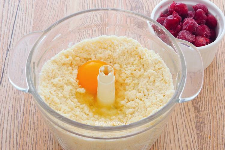 В масляную крошку разбить куриное яйцо