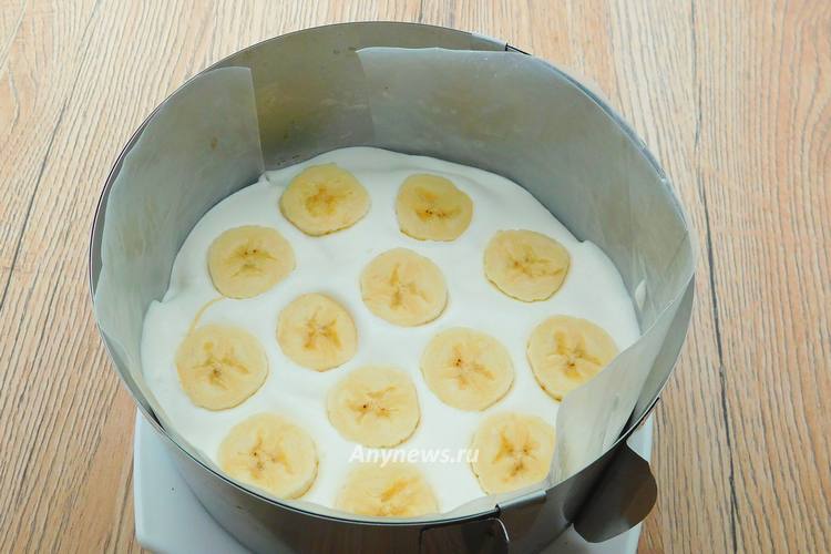 Размазать треть сметанного крема, выложить бананы