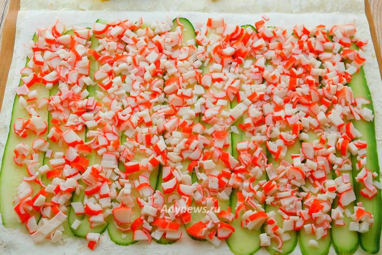 Крабовые палочки нарезать некрупно, распределить на лаваш