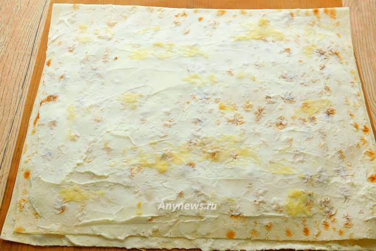 Смазать лаваш сверху творожным сыром, посыпать чесноком