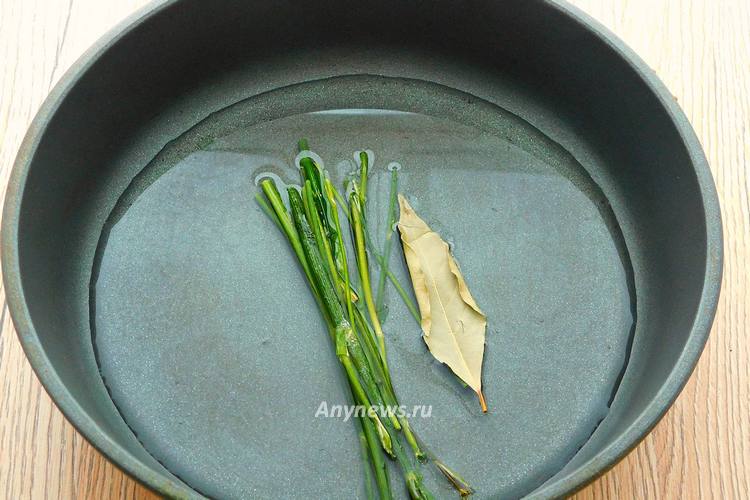 В сковородку поместить лавровый лист и петрушку, влить воду