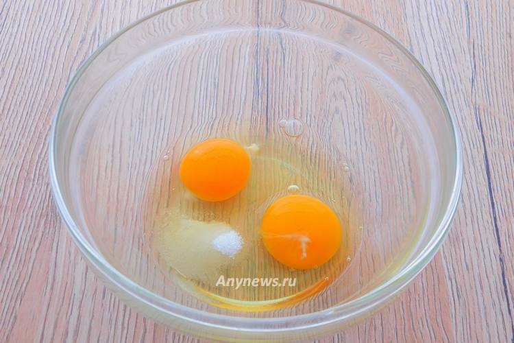 В миску разбить яйца, добавить соль и сахар