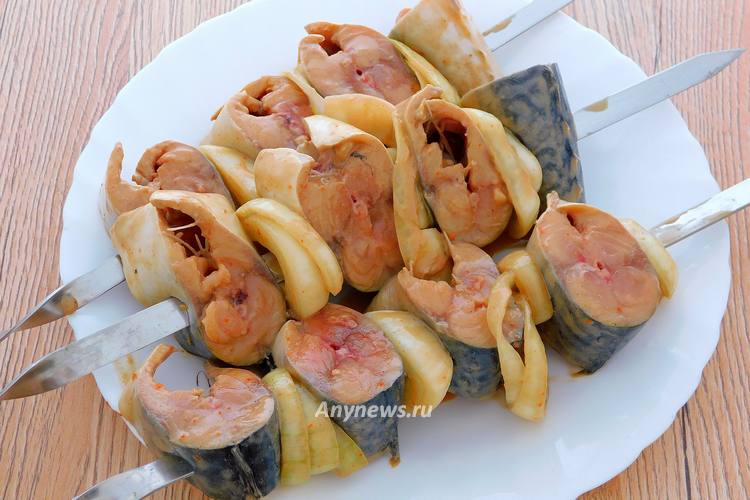 Нанизывайте рыбу на шампуры и чередуйте с луком